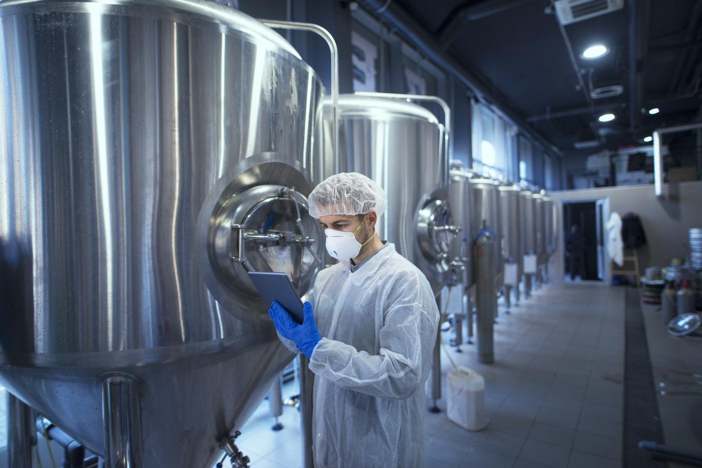 Technician checking production tanks